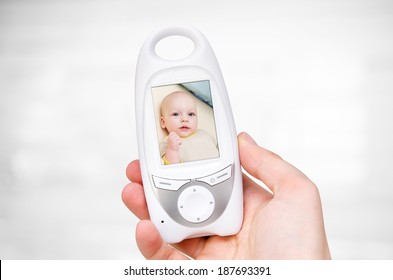 Hand Holding Video Baby Monitor For Security Of The Baby 