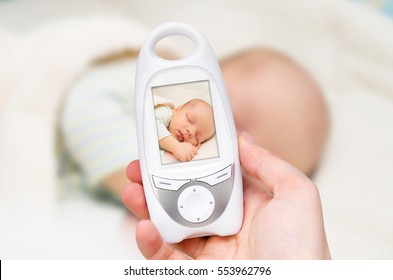 Hand Holding Video Baby Monitor For Security Of The Baby