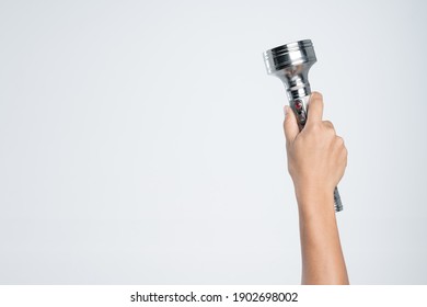 Hand holding vintage aluminium flashlight powered by size D batteries on white background - Powered by Shutterstock