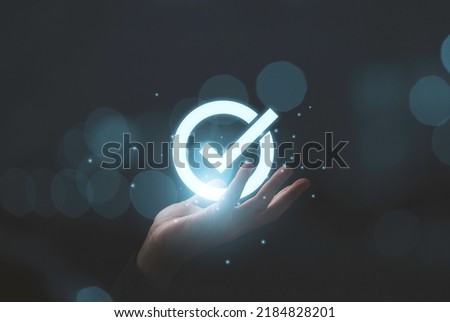 Hand holding virtual glow correct sign and tick correct mark to approve document and project concept.