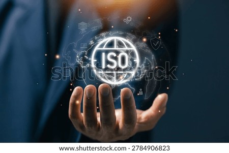 Hand holding virtual ISO certification globe interface, international quality management standard, compliance system and global business technology concept.