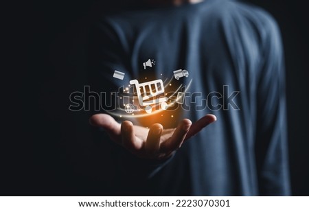 Hand holding virtual shopping cart icons , Technology online shopping business delivery e-commerce concept.