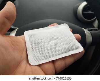 Hand Holding Hand Warmer In Car