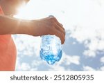 Hand holding water bottle, drinking water, body care health concept 