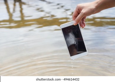 Hand holding a wet smartphone / Waterproof smartphone concept