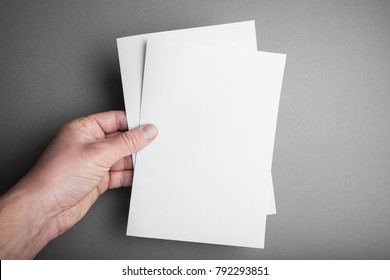 Hand Holding White Blank Paper A5 Sheet Mockup. Leaflet Document Surface Design.