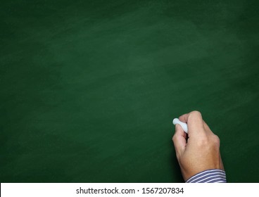 Hand holding white chalk with blank blackboard - Shutterstock ID 1567207834