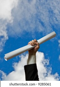 Hand Holding A White Diploma Over Sky Background