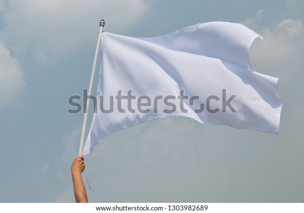 Hand\
up holding white flag pole the concept of give up.\
