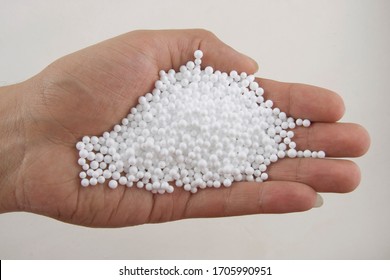 Hand holding white polystyrene foam beads ball drop