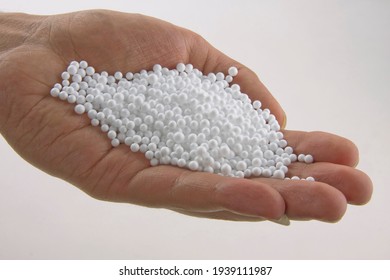 Hand holding white polystyrene foam beads ball drop