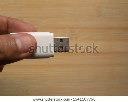 Hand holding white USB flash pen drive