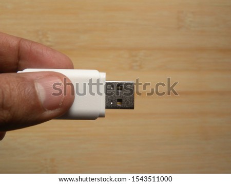 Hand holding white USB pen drive