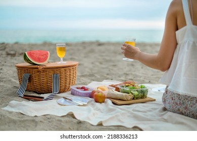 Hand Holding A Wine Glass On The Beach. The Picnic In Summer With Nice Sand, Sea And Sky. Chill And Good Summer Vibe