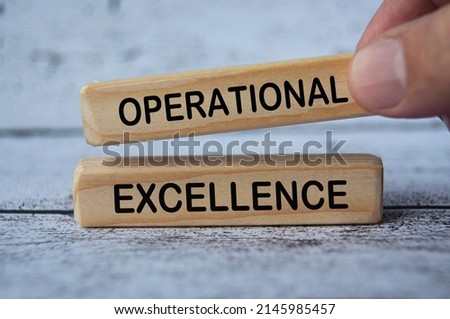 hand holding wooden block with text - Operational excellence. Business strategy concept