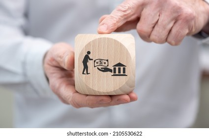 Hand Holding A Wooden Cube With Symbol Of Government Aid Concept