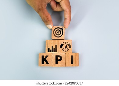 hand holding a wooden square with a KPI or Key Performance Indicator icon. business goals, performance results, and indicators - Shutterstock ID 2242090837