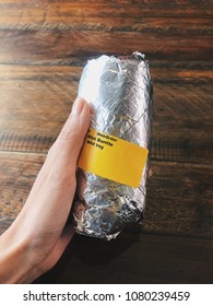 Hand Holding Wrapped Burrito