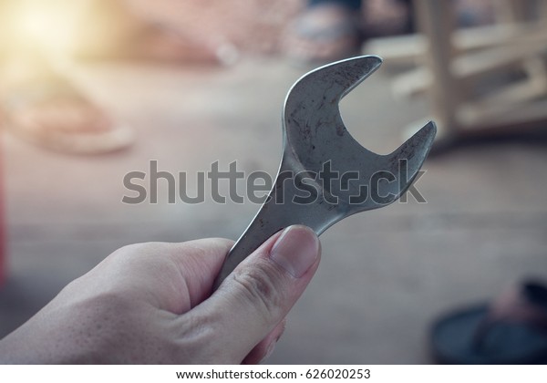 Hand holding a\
wrench