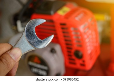 hand holding a Wrench and Blurred  small Engines background, repairing an engine,selective focus