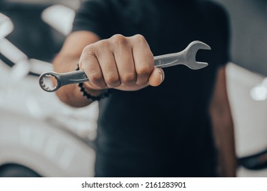 Hand holding a wrench with a car repairs, professional auto mechanic - Shutterstock ID 2161283901