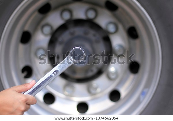 Hand holding a
wrench on  blurred
background.