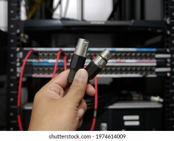 hand holding XLR cable connector at TV station.