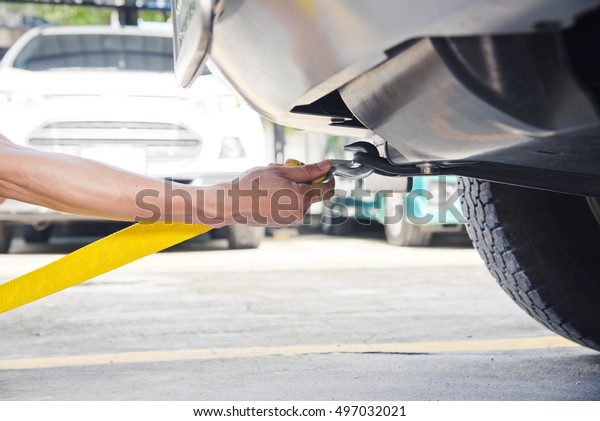 Hand
holding yellow car towing strap with car, car
towing