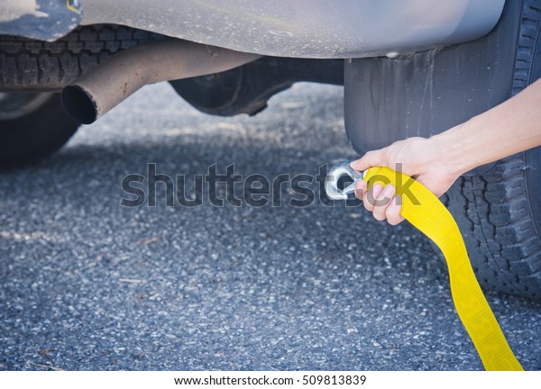 Hand holding yellow car towing strap with car, car
towing, towing rope 