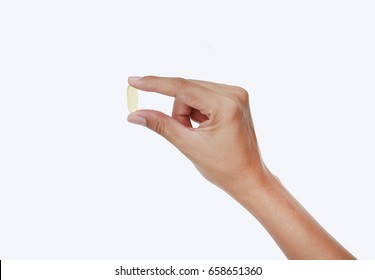 Hand holding yellow fish oil capsule isolated on white background