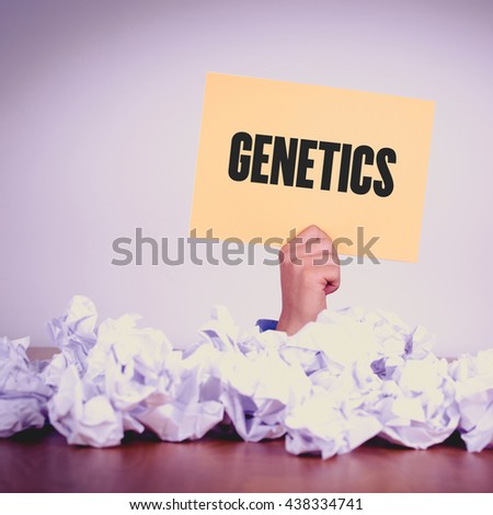 HAND HOLDING YELLOW PAPER WITH GENETICS CONCEPT