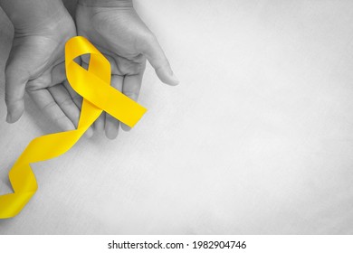 Hand holding Yellow ribbon on white background, copy space. Bone cancer, Sarcoma Awareness, childhood cancer, cholangiocarcinoma, gallbladder cancer, world Suicide Prevention Day. Health concept.