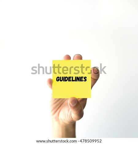 Hand holding yellow sticky note written GUIDELINES word