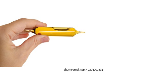 A Hand Holds An Ampoule With Liquid Contents. Glass Medicine Vial Mockup Design. Medical Dietary Supplements. Vitamin Complex. Person Holds A Medicinal Product Close-up. Cosmetics Elixir. Copy Space.