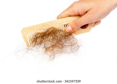 Hand holds bunch of hair on the comb. Hair loss concept
