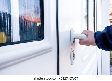 Hand Holds Doorknob On Front Door