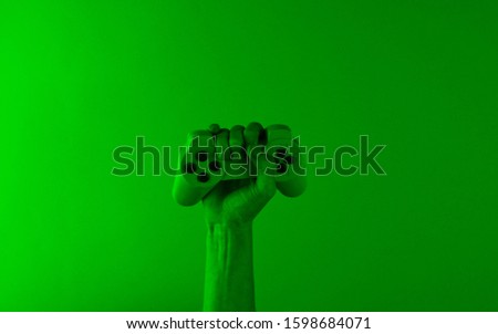Hand holds a gamepad with green holographic light. Minimalism, concept art