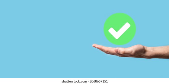 Hand holds green icon Check mark,Check Mark Sign, Tick Icon,right sign,circle green checkmark button,Done.On dark background.Banner.Copy space.Place for text - Shutterstock ID 2068657151