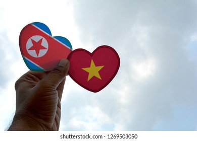 Hand holds a heart Shape North Korea and Vietnam flag, love between two countries