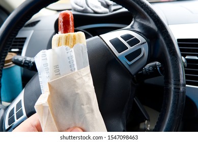 Hand Holds Hot Dog In A Car, Close Up Photo