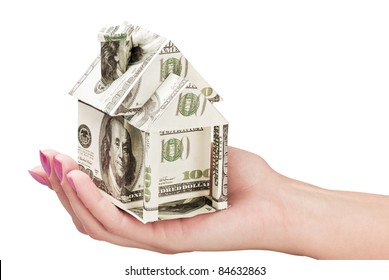 hand holds a house made from dollars