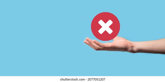 Hand holds icon,cancellation symbol,cancel icon.Cross mark flat red icon.round X mark.cancel button.Wrong.cross mark rejection.Declined.On dark background.Banner.Copy space.Place for text