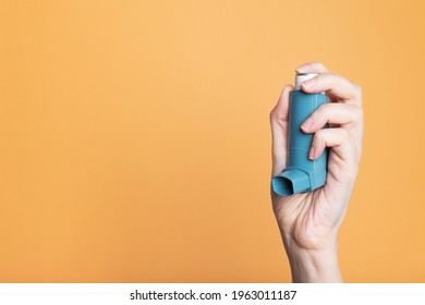 Hand holds inhaler to treat asthma. World Asthma Day. Concept of allergy care. Copy space - Powered by Shutterstock