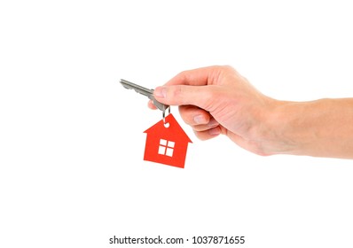 The hand holds the keys with the red house keychain. Purchase of apartments. House in hands. Close up. Isolated on a white background.
