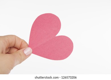 A Hand Holds On To A Pink Heart Cut Out Of Construction Paper.