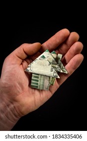 Hand Holds Origami Paper Money House For Real Estate And Housing Market Concept