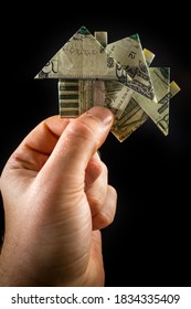 Hand Holds Origami Paper Money House For Real Estate And Housing Market Concept