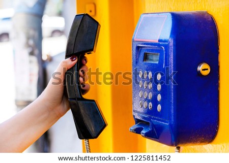 The hand holds a payphone tube. Close-up. A call from the pay station. The concept Access before telephone communication. An anonymous call from the public telephone.