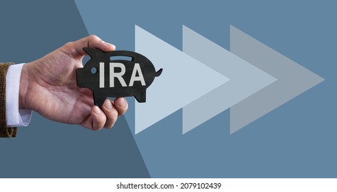 Hand Holds Piggy Bank With IRA Individual Retirement Account.