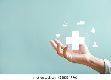 A hand holds a plus icon for medical care, indicating advantages. Health insurance health concept featuring access to welfare health and room for content. - Shutterstock ID 2380349963